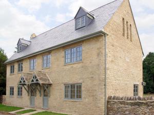 an old brick church with a gambrel roof at Kites Gate Cottage in Kingham +16 photos