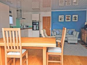 a kitchen and living room with a wooden table and chairs at Dinky Daze - Ukc7071 in Brundall