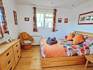 a bedroom with a bed and a dresser and a chair at Dinky Daze - Ukc7071 in Brundall