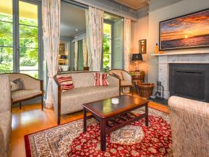a living room with a couch and a fireplace at Plas Bodegroes in Pwllheli