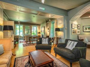 a living room with couches and a table at Plas Bodegroes in Pwllheli