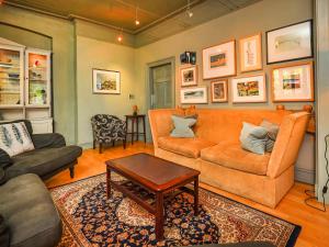 a living room with a couch and a table at Plas Bodegroes in Pwllheli