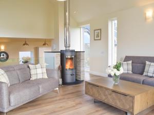a living room with a couch and a fireplace at Falcon Cottage in Linlithgow