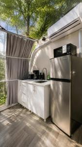 a kitchen with a stainless steel refrigerator in a tent at Studio Capsule Sand Bay #16 in Dillon