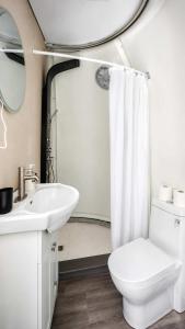 a white bathroom with a toilet and a sink at Studio Capsule Sand Bay #16 in Dillon