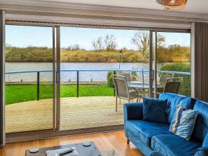 a living room with a blue couch and a large sliding glass door at River View-Ukc6112 in Brundall