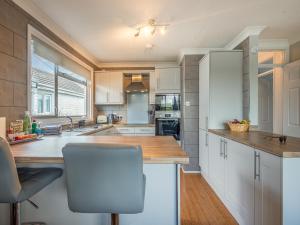a kitchen with white cabinets and a wooden counter top at River View-Ukc6112 in Brundall +10 photos
