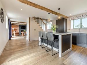 a kitchen and living room with a counter and stools at The Dairy - Uk44130 in Baystonhill
