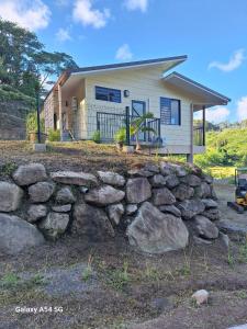 a stone wall in front of a house at Temoe'ani House in Uturoa