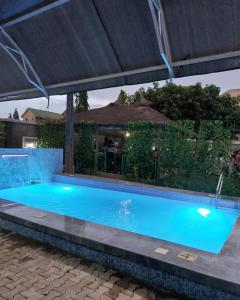 a large blue swimming pool under a canopy at #5 Apartment in Parma