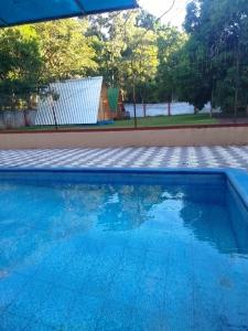a swimming pool with blue water in a yard at Glamping Guavirá in Ciudad del Este