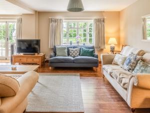 a living room with a couch and a tv at Lower Barrowfield Farm in Beaminster
