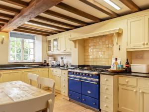 a kitchen with white cabinets and blue appliances at Lower Barrowfield Farm in Beaminster +17 photos