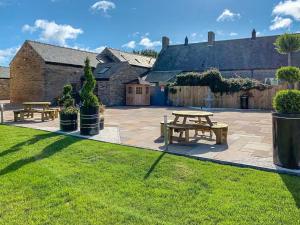 a patio with two picnic tables in a yard at Wagtail Cottage-Ukc6984 in Castleside