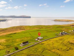a red stop sign on a field next to a body of water at The Two Byres in Trumpan
