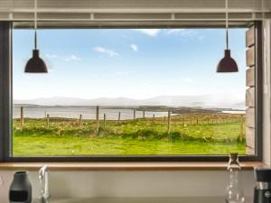 a kitchen window with a view of the ocean at The Two Byres in Trumpan +15 photos