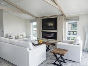 a living room with white furniture and a tv at River Tees Lodge - Ukc4064 in Nunthorpe