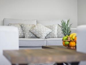 a white couch with pillows and a bowl of fruit at River Tees Lodge - Ukc4064 in Nunthorpe