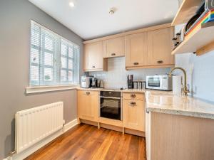 a kitchen with wooden cabinets and a counter top at Lundin Links - Ukc6916 in Turnberry
