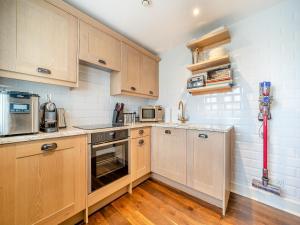 a small kitchen with wooden cabinets and appliances at Lundin Links - Ukc6916 in Turnberry