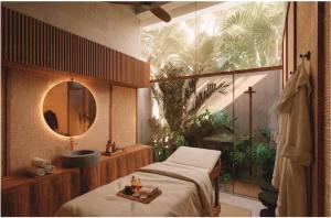 a bedroom with a bed and a mirror and a sink at NANANA Hotel de Mar - Solo Adultos in Puerto Escondido