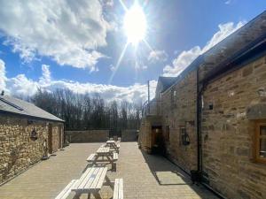 a group of benches sitting on a patio at Swallow Cottage-Ukc6983 in Castleside