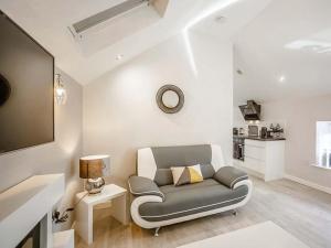 a living room with a gray couch and a table at Swallow Cottage-Ukc6983 in Castleside