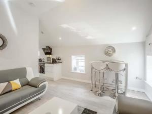 a white living room with a couch and a table at Swallow Cottage-Ukc6983 in Castleside +4 photos