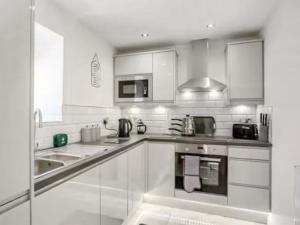 a white kitchen with a sink and a microwave at Barn Owl Cottage- Ukc6985 in Castleside
