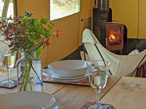 a table with plates and glasses and a fireplace at The Apple Bobber - Ukc7130 in Cratfield