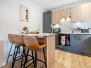 a kitchen with a counter and two bar stools at Star Cottage in Ringwood +9 photos