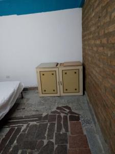 a room with a bed and two cabinets next to a brick wall at El buen descanso in Trelew