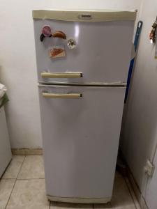 an old white refrigerator in a kitchen at El buen descanso in Trelew