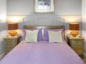a bedroom with a purple bed with two lamps at Seaspray in Buckie