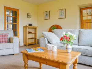 a living room with two couches and a coffee table at Osprey Cottage - Uzq in Kirkton of Airlie +20 photos