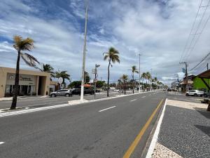 an empty street with palm trees and cars on the road at Tropical Praia Hotel in Aracaju