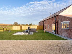 a brick house with a patio and grass yard at The Foundary - Uk36319 in Whitchurch