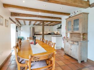 a large kitchen with a wooden table and chairs at Wern Farm Barn in Cwm-du