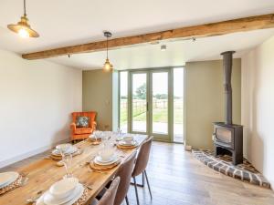 a dining room with a long table and a wood stove at The Stables - Uk44139 in Baystonhill