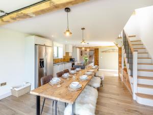 a kitchen and dining room with a long wooden table at The Stables - Uk44139 in Baystonhill