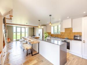 a large kitchen with white cabinets and a long island at The Stables - Uk44139 in Baystonhill