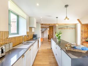 a kitchen with white cabinets and a large counter top at The Stables - Uk44139 in Baystonhill