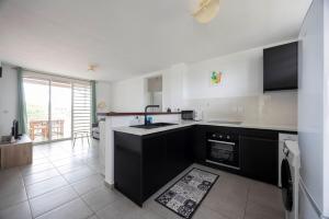 a kitchen with a sink and a stove at Appartement bois de chaumes in Cayenne +14 photos