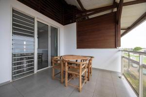 a dining room with a table and chairs on a balcony at Appartement bois de chaumes in Cayenne