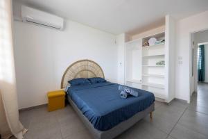 a bedroom with a bed with a blue comforter at Appartement bois de chaumes in Cayenne