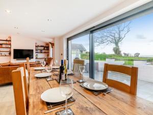 a dining room with a wooden table and a large window at Ty Eufron in St. Davids