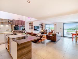 a kitchen and living room with a large window at Ty Eufron in St. Davids