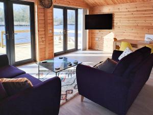 a living room with two couches and a glass table at Nature's Nook in Brundall