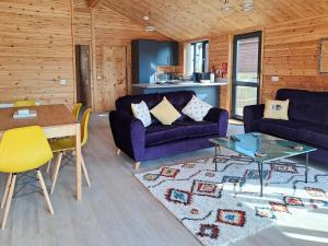 a living room with a purple couch and a table at Nature's Nook in Brundall