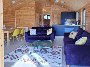 a living room with two purple couches and a table at Nature's Nook in Brundall